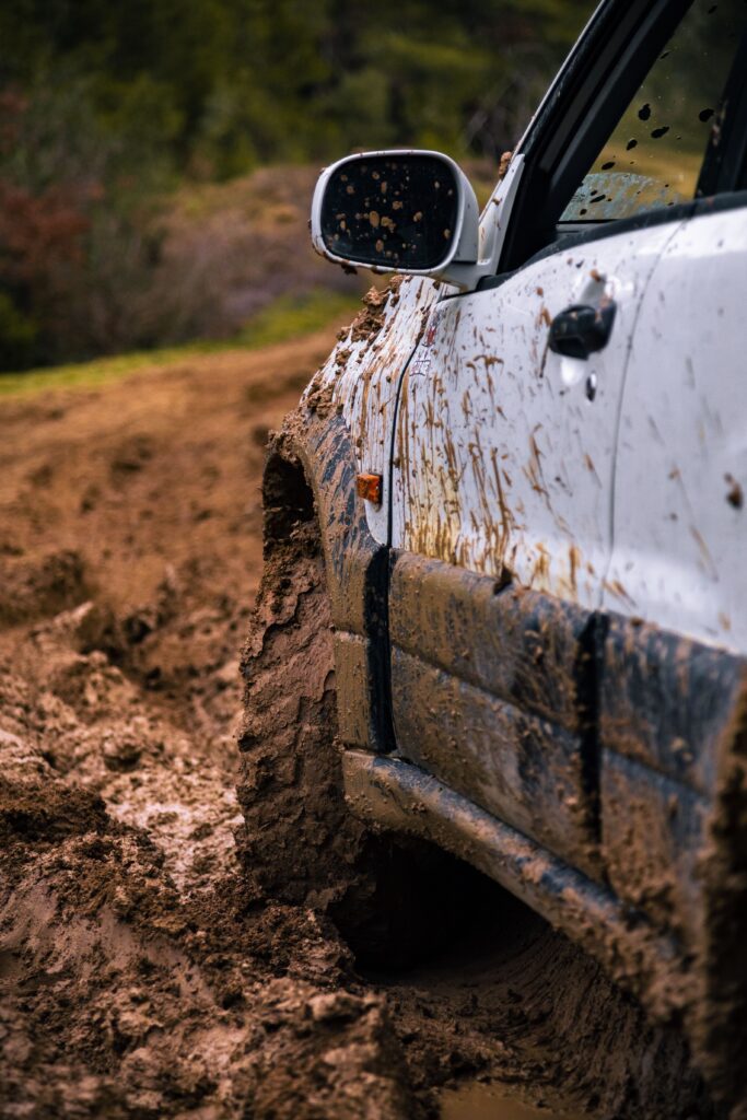 A rugged vehicle conquer muddy off-road terrain, showcasing our vehicle recovery services Colorado Springs.